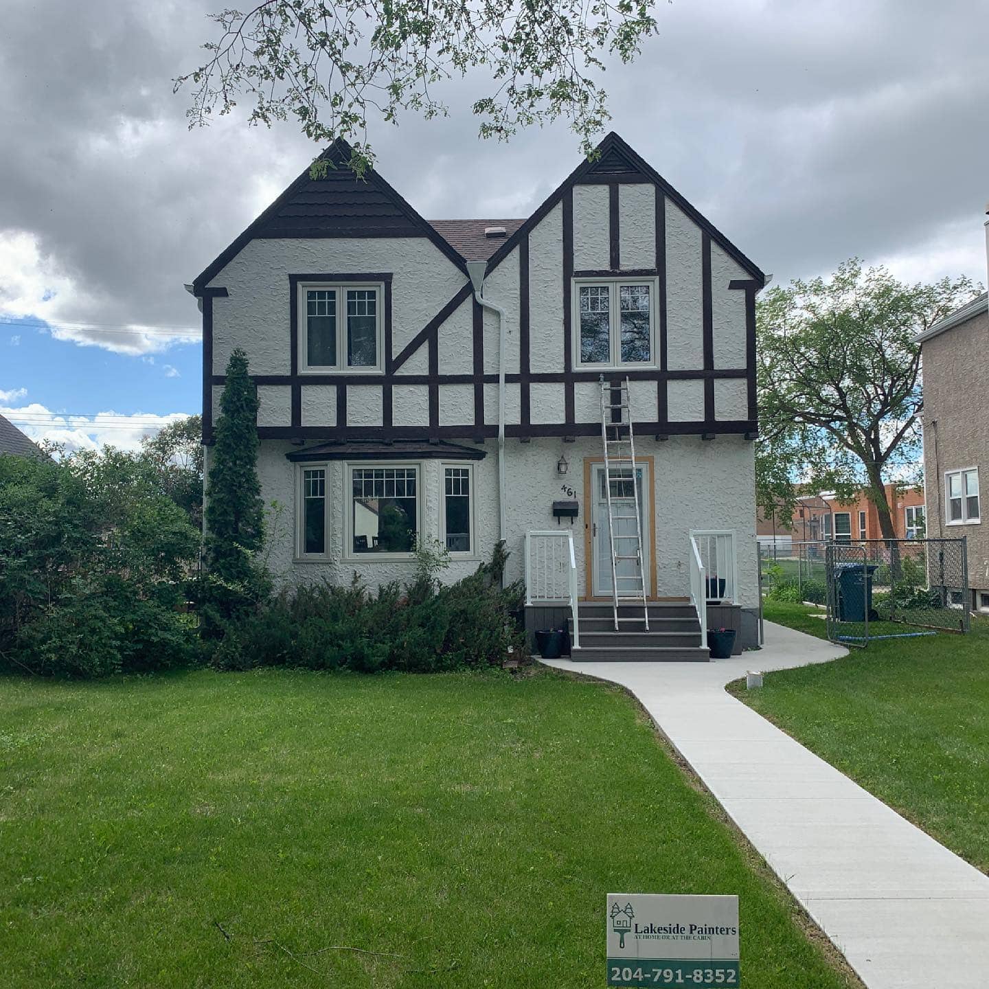 Exterior repaint in progress — the same Winnipeg two-storey before its new colour