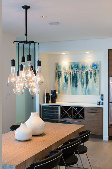 Dining area with sculptural chandelier and built-in wine storage — W Design Group project