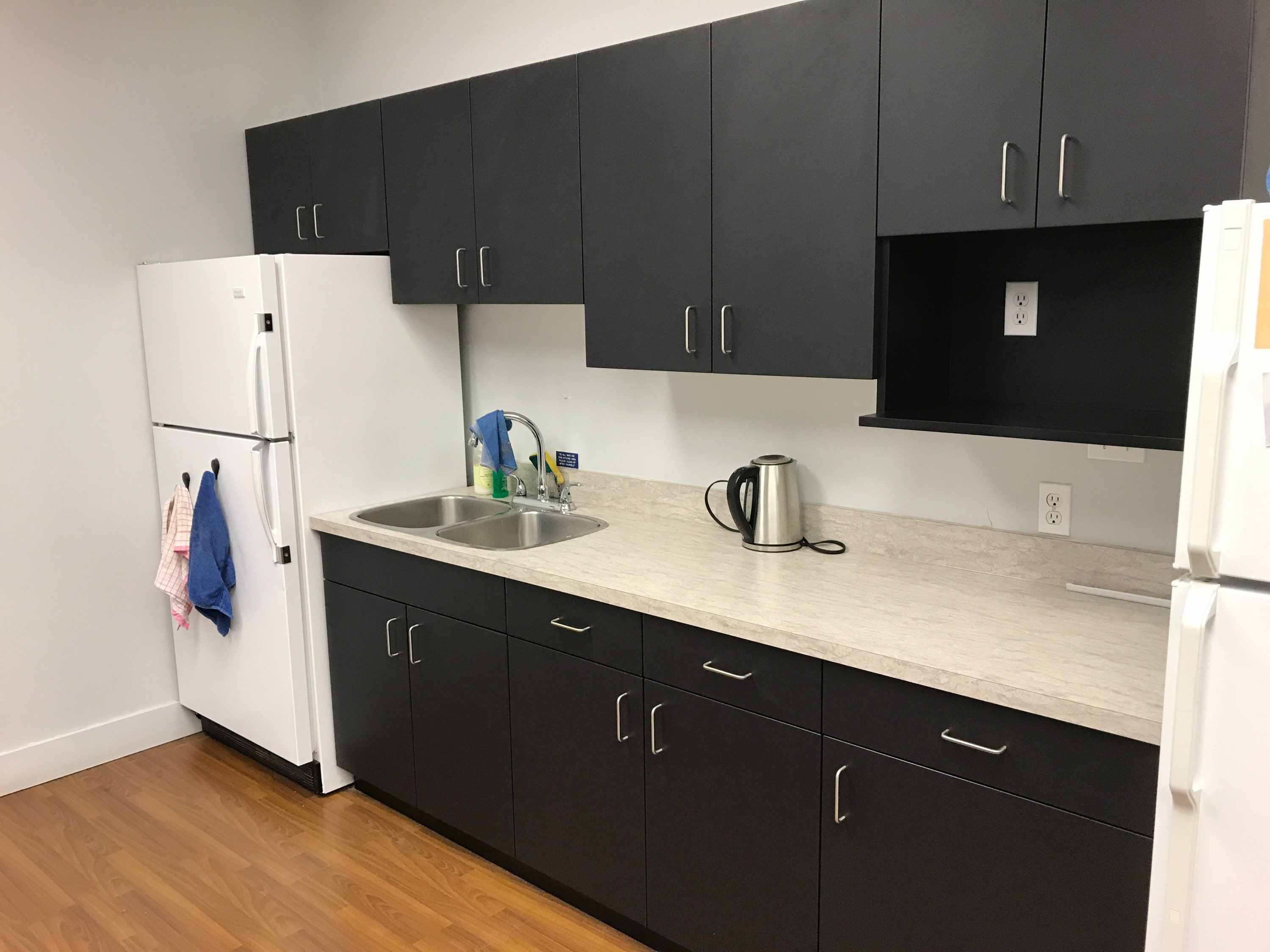 black cabinets with tan countertop comme