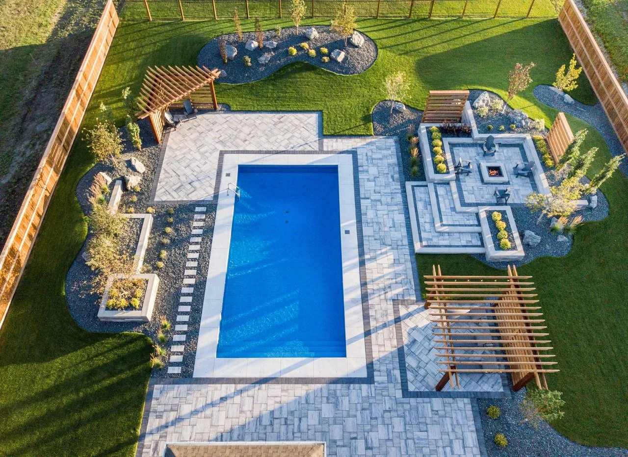 A beautifully landscaped outdoor space by Silverstone Landscaping, featuring lush greenery and a cozy seating area, repr