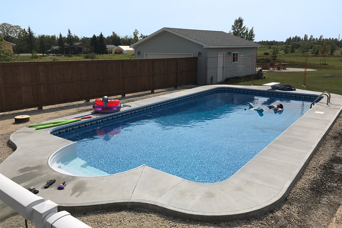 This outdoor wide angle photograph captures a sprawling residential backyard showcasing the newly installed Budd custom 